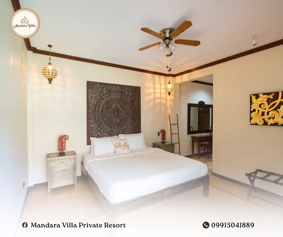 Twin bedroom with intricate Balinese carved mandala headboard and warm lantern lighting