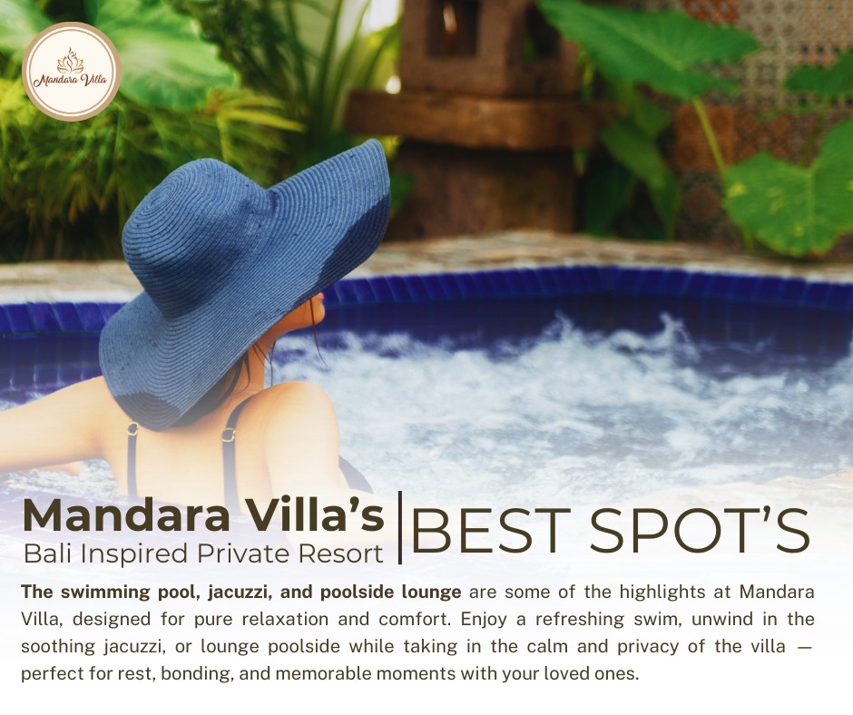 Woman in wide-brim hat relaxing in the heated jacuzzi with tropical plants and stone waterfall feature